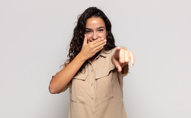 Pretty young woman laughing at you, pointing to camera and making fun of or mocking you