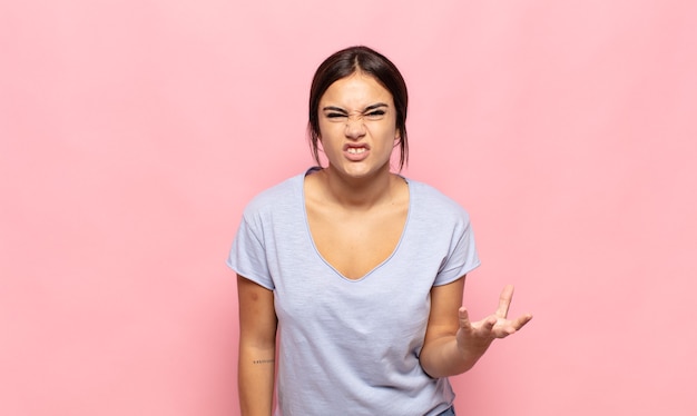 Pretty young woman looking angry, annoyed and frustrated screaming wtf or what's wrong with you