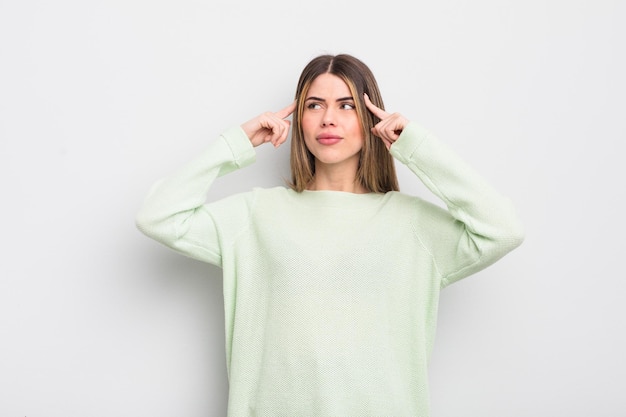 Pretty young woman looking concentrated and thinking hard on an idea imagining a solution to a challenge or problem