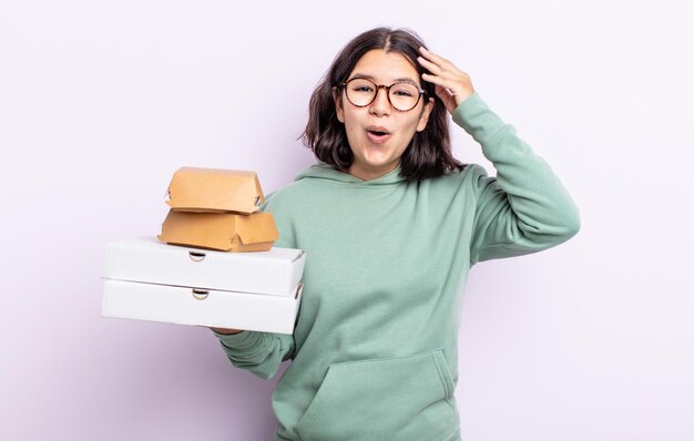 Pretty young woman looking happy, astonished and surprised. fast food take away concept