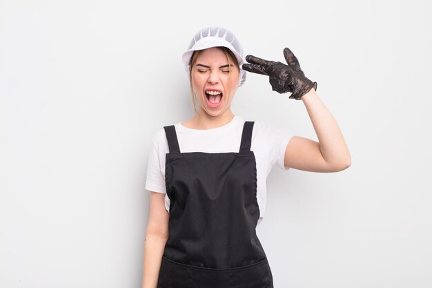 Pretty young woman looking unhappy and stressed suicide gesture making gun sign fishmonger concept