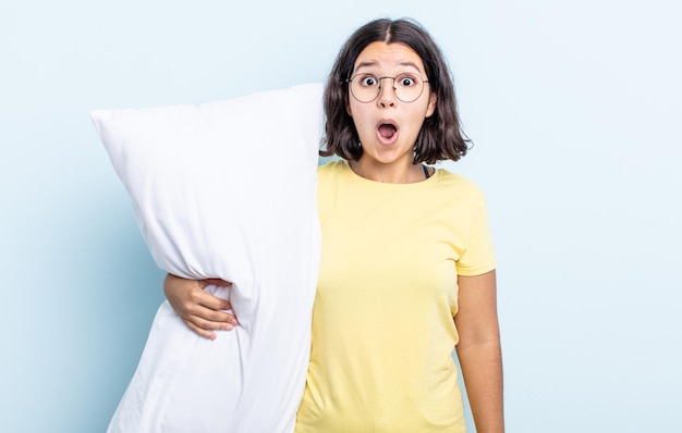 Pretty young woman looking very shocked or surprised. bed concept