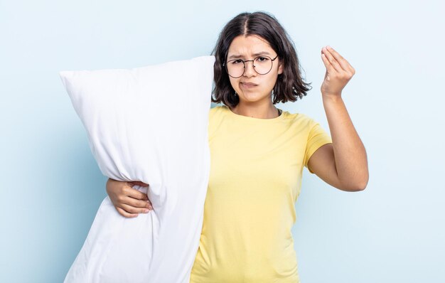 Pretty young woman making capice or money gesture, telling you to pay. bed concept