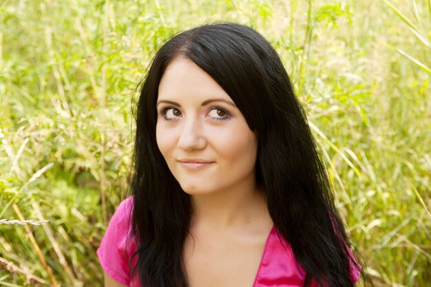 Pretty young woman outdoor in the grass in summertime