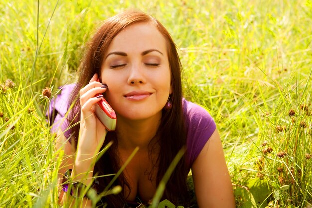 Pretty young woman outdoor in the grass in summertime