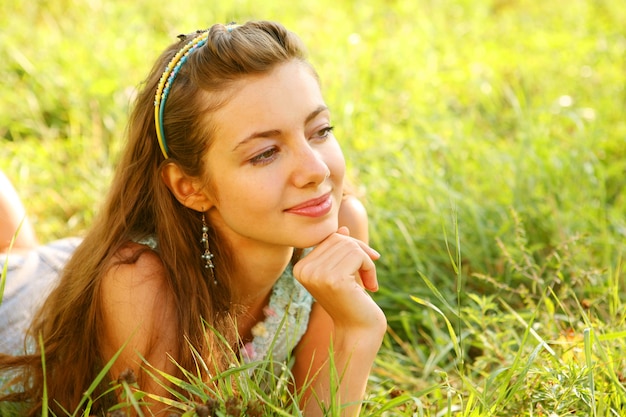 Pretty young woman outdoor in the grass in summertime