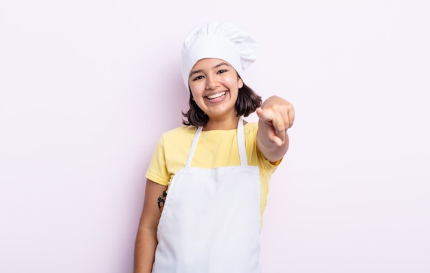 Donna abbastanza giovane che indica alla macchina fotografica che ti sceglie. concetto di chef