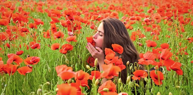 Pretty young woman in poppies red field.