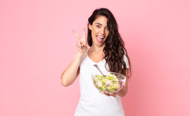 Pretty young woman preparing a salad