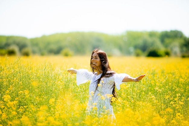 Pretty young woman in the rapeseed field