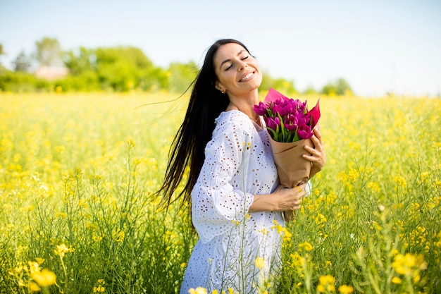 Bella giovane donna nel campo di colza