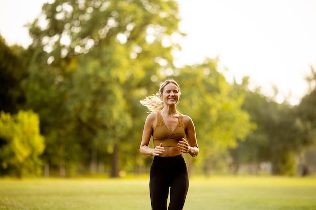 Pretty young woman running in park