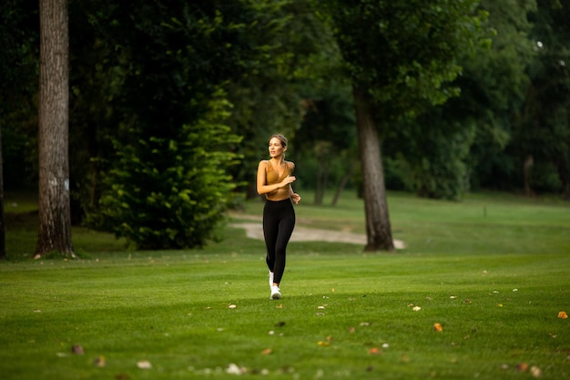 Pretty young woman running in park