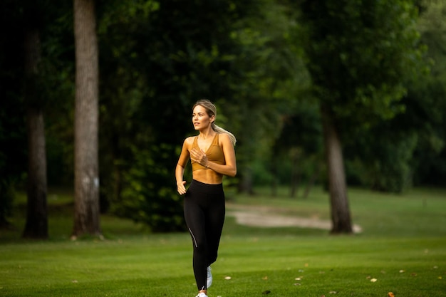 Pretty young woman running in park