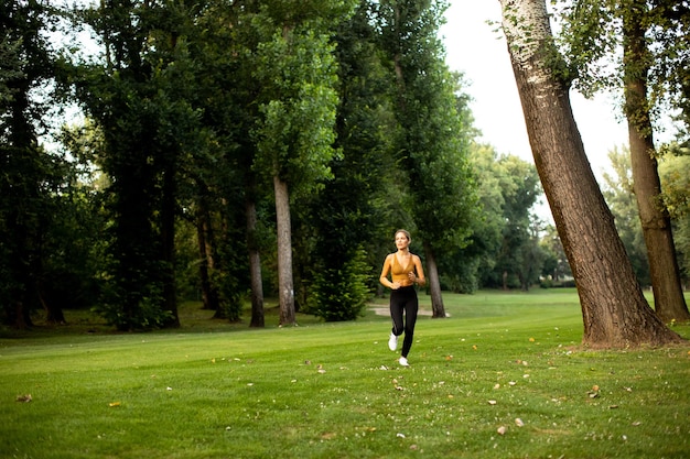 Pretty young woman running in park