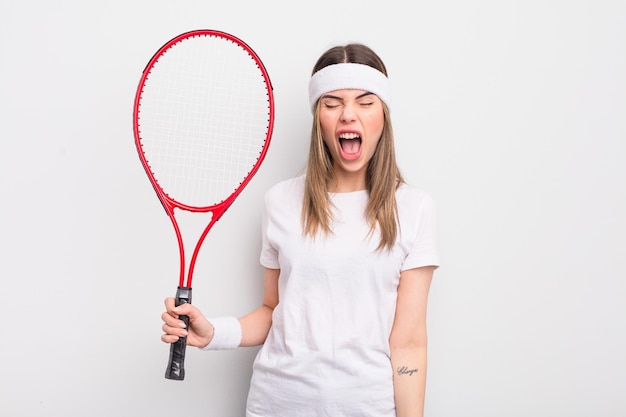 Pretty young woman shouting aggressively looking very angry tennis concept