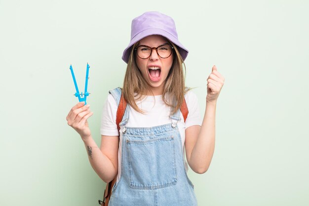 Pretty young woman shouting aggressively with an angry expression student concept