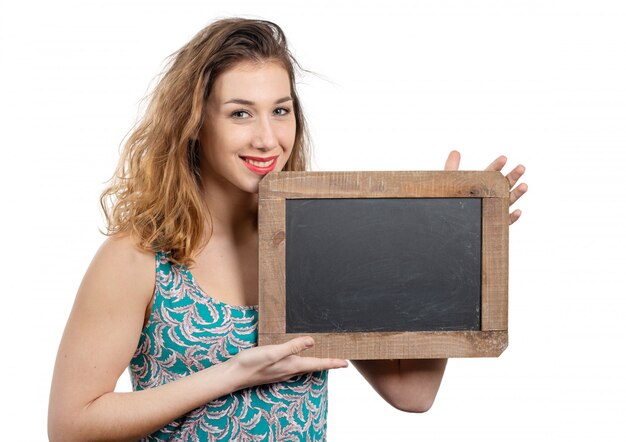 Pretty young woman showing a small chalkboard isolated on white