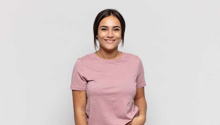 Photo pretty young woman smiling to camera with crossed arms and a happy, confident, satisfied expression, lateral view