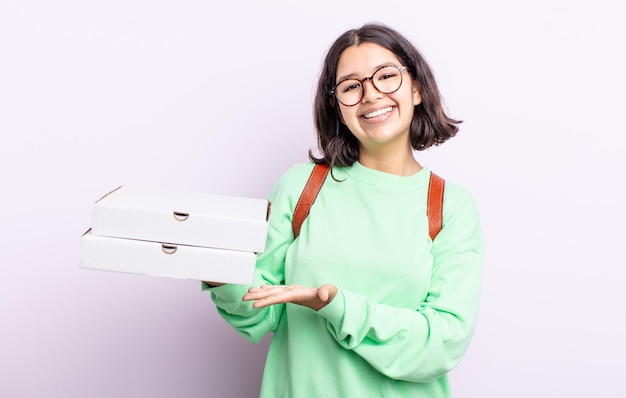 Pretty young woman smiling cheerfully, feeling happy and showing a concept. take away concept