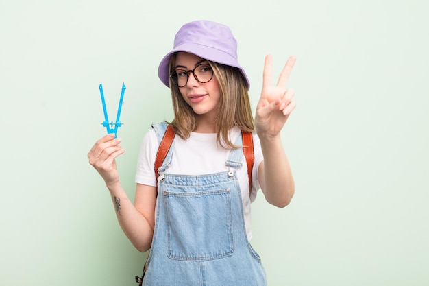 Pretty young woman smiling and looking happy, gesturing victory or peace. student concept