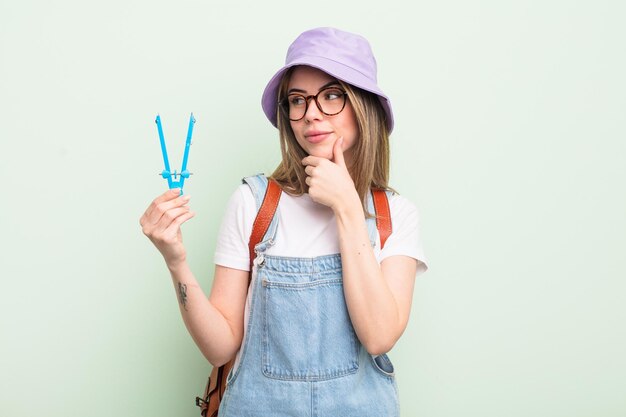 Pretty young woman smiling with a happy, confident expression with hand on chin. student concept