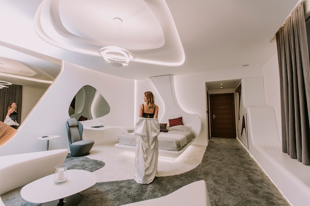 Pretty young woman standing in the modern apartment