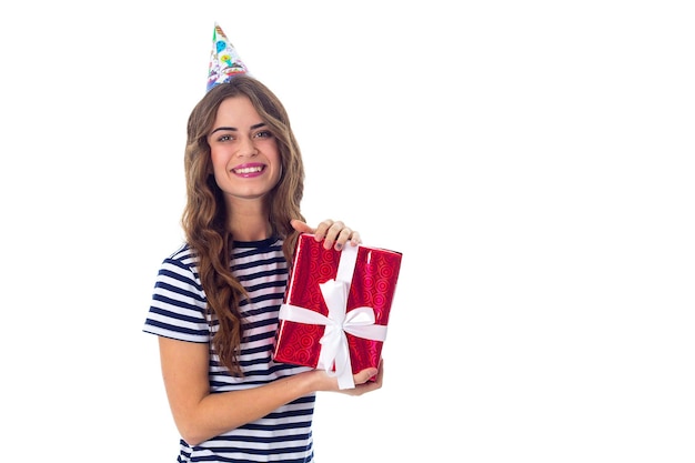 Красивая молодая женщина в раздетой футболке и праздничной кепке с красным подарком в студии