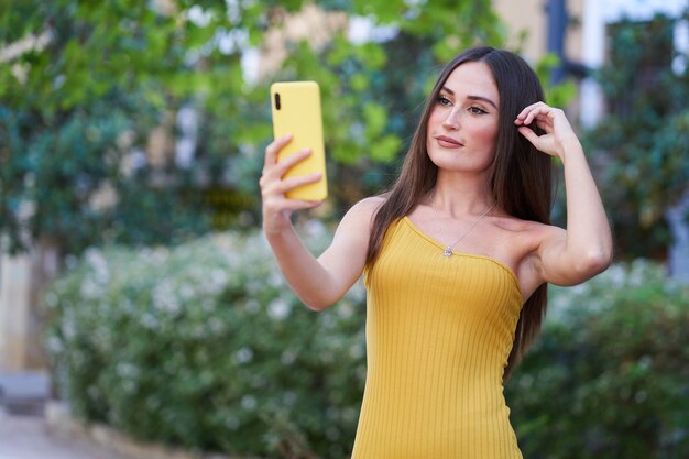 Pretty young woman, taking a selfie with her smartphone