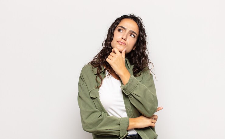 Photo pretty young woman thinking, feeling doubtful and confused, with different options, wondering which decision to make