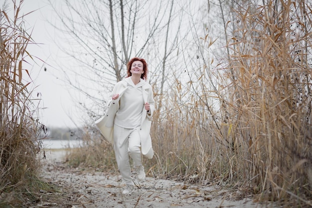 Pretty young woman in trendy white clothes poses in motion