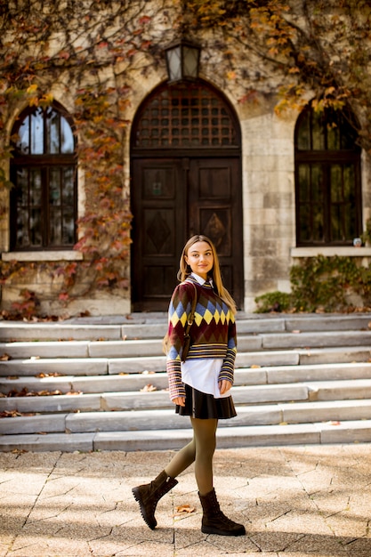 Foto giovane donna graziosa che cammina nel parco di autunno