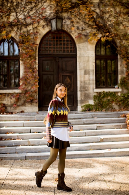 Pretty young woman walking in the autumn park