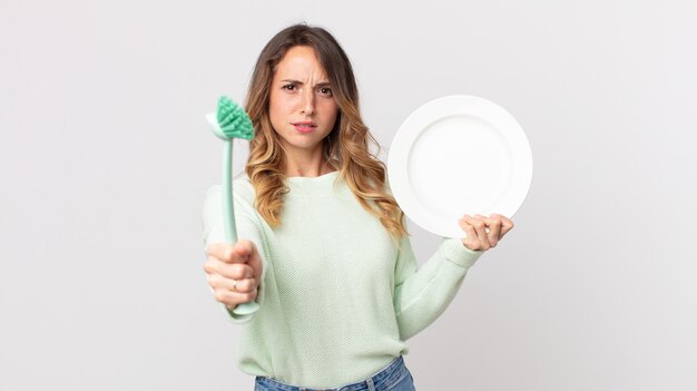 Pretty young woman washing dishes concept