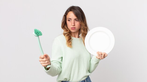 かなり若い女性の食器洗いのコンセプト