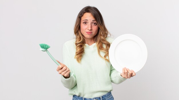 かなり若い女性の食器洗いのコンセプト