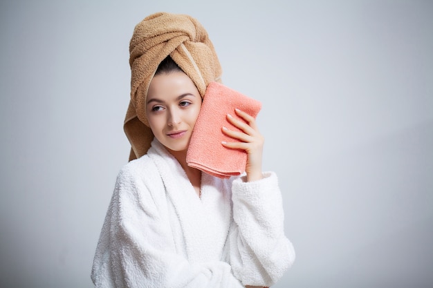 Pretty young woman wipes the face towel after taking a shower