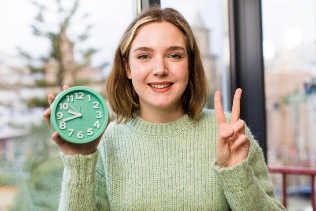 Photo pretty young woman with an alarm clock house interior design