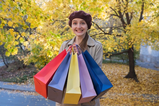 Pretty young woman with colorful shopping bags outdoors Autumn promotion