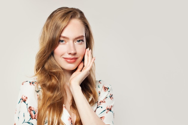 Pretty young woman with ginger hair on white background