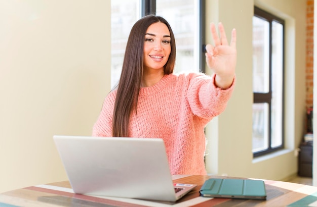 Pretty young woman with a laptop on a desk at home