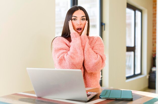 Pretty young woman with a laptop on a desk at home