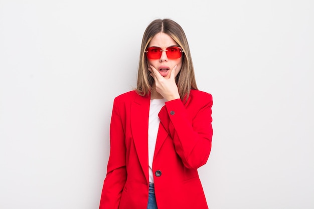 Pretty young woman with mouth and eyes wide open and hand on chin