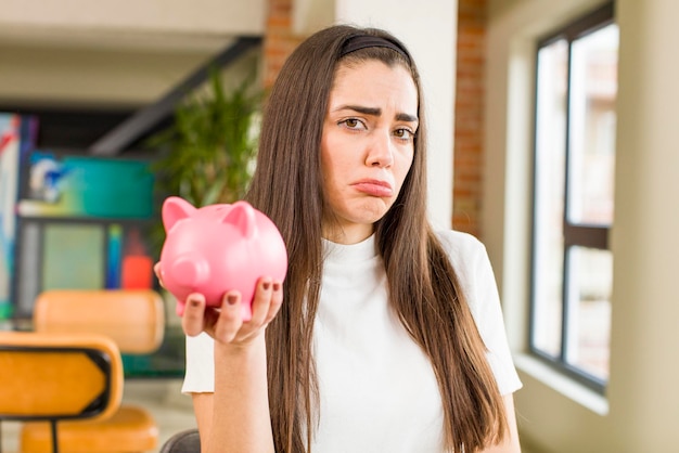 Pretty young woman with a piggy bank savings concept house interior design
