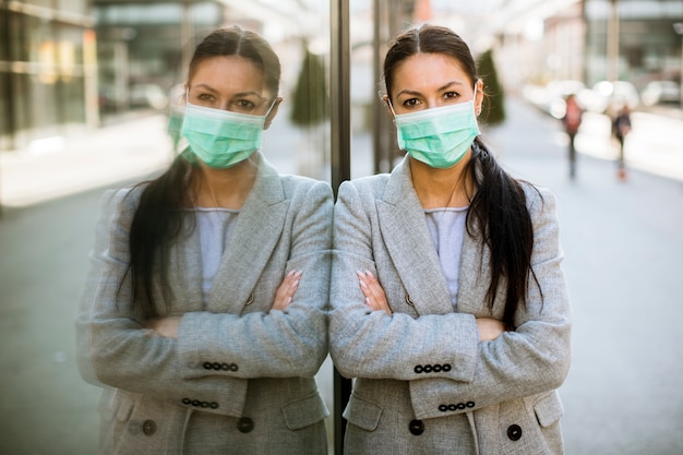 Pretty young woman with protective facial mask on the street