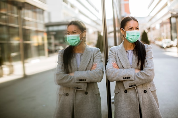 Pretty young woman with protective facial mask on the street