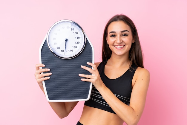 Pretty young woman with weighing machine  with weighing machine
