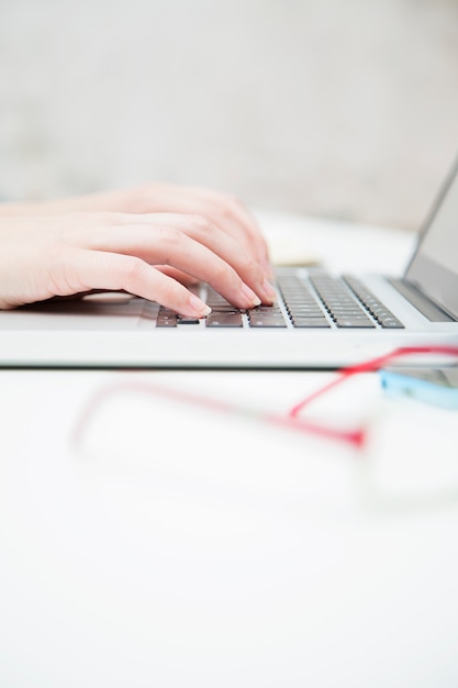 Pretty young woman working on laptop in the office