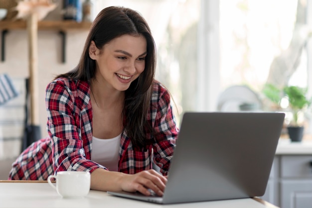 Foto giovane donna graziosa che lavora al computer portatile