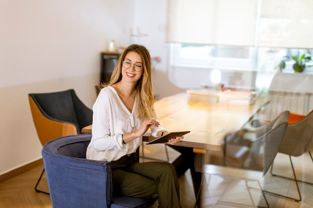 Pretty young woman working with digital tablet in the office